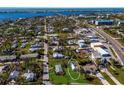 Aerial view showing a small house on a lot with surrounding houses and water at 4420 119Th W St, Cortez, FL 34215