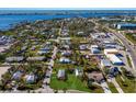 Aerial view showing a small house on a lot with surrounding houses and water at 4420 119Th W St, Cortez, FL 34215