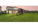 Expansive backyard featuring a lush green lawn and a charming playset, perfect for Gathering fun and outdoor activities at 5548 Summit Gln, Bradenton, FL 34203