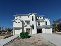 Newly constructed three-story home with white siding, gray metal roof, and attached two-car garage at 597 Buttonwood Dr, Longboat Key, FL 34228