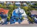 Aerial view of a two-story home with metal roof, large porch, and surrounding tropical landscape at 598 Lyons Ln, Longboat Key, FL 34228