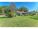 House exterior showcasing a large green lawn and mature trees at 6280 Uplands Blvd, Sarasota, FL 34243