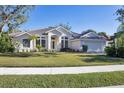 House exterior showcases a light-colored facade, tile roof, and manicured lawn at 6615 Hunter Combe Xing, University Park, FL 34201