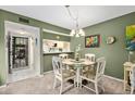Charming dining area with a glass-top table and white chairs at 1720 Glenhouse Dr # 330, Sarasota, FL 34231