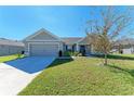 House exterior showcasing a gray color scheme, attached garage, and well-manicured lawn at 3030 58Th E Way, Palmetto, FL 34221