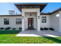 Modern front entrance with a black door and white columns at 319 Sherbourne St, Port Charlotte, FL 33954