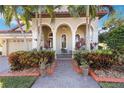 Inviting front porch with brick walkway and tropical landscaping at 3706 80Th E Dr, Sarasota, FL 34243