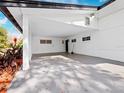 Covered carport with concrete flooring and side yard access at 3825 Sarasota Golf Club Blvd, Sarasota, FL 34240