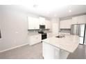 Modern kitchen featuring white cabinets, granite countertops, and stainless steel appliances at 4109 Quiet Rain Ct, Palmetto, FL 34221