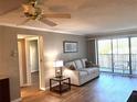 Bright living room with hardwood floors, comfy sofa, and sliding glass doors to balcony at 4119 61St Avenue W Ter # 308, Bradenton, FL 34210
