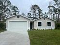 Newly built home with a white garage door and landscaping at 5274 Neon Ave, North Port, FL 34291
