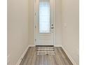 Light and bright foyer with wood-look flooring and a white door at 6043 Bluestar Ct, Bradenton, FL 34211