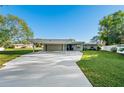 Modern home exterior with carport and well-manicured lawn at 608 69Th W Ave, Bradenton, FL 34207