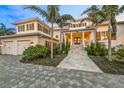 Elegant waterfront home with a three-car garage and manicured landscaping at 641 Key Royale Dr, Holmes Beach, FL 34217