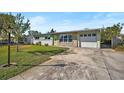 Front view of a ranch home with a large yard and driveway at 6712 Georgia Ave, Bradenton, FL 34207