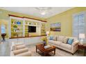 Living room with built-in shelving, comfortable seating, and a warm color palette at 10643 Old Grove Cir, Bradenton, FL 34212