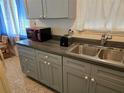 Simple kitchen with gray cabinets and stainless steel sink at 1205 Harvard Ave, Bradenton, FL 34207