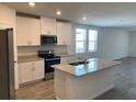 Modern kitchen featuring white cabinets, granite countertops, and stainless steel appliances at 160 Lazy Shore Dr, Nokomis, FL 34275