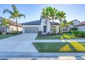 Front view of a one-story house with palm trees and a two-car garage at 249 Palmaria Ct, Nokomis, FL 34275