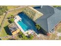 Overhead view of the backyard pool, tiki hut, and deck area surrounded by lush landscaping at 25205 67Th E Ave, Myakka City, FL 34251