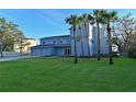 Two-story waterfront home with a large lawn and palm trees at 3804 Bayside Dr, Bradenton, FL 34210