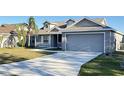 Two-story house with gray siding, a two-car garage, and a palm tree at 4042 Kingsfield Dr, Parrish, FL 34219