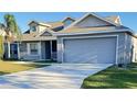 Two-story house with gray siding, a two-car garage and a small porch at 4042 Kingsfield Dr, Parrish, FL 34219