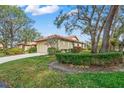 Tan house with brown tile roof, manicured hedges, and a two-car garage at 4577 Pine Green Trl # 2, Sarasota, FL 34241