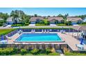 Community pool with surrounding lounge chairs and tables at 6713 Stone River Rd # 205, Bradenton, FL 34203