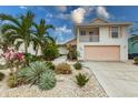 Charming two-story home featuring a balcony and lush tropical landscaping at 109 Tortuga Dr, Nokomis, FL 34275