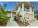 Two-story home featuring a balcony, front yard landscaping, and a clean exterior at 109 Tortuga Dr, Nokomis, FL 34275