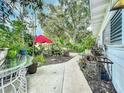 Side yard with a paved walkway, plants, and outdoor furniture at 1420 22Nd W St, Bradenton, FL 34205