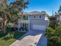 Contemporary two-story home with gray stucco, a two-car garage, a balcony, and lush landscaping at 2586 Prospect St, Sarasota, FL 34239