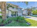 Modern two-story home with a gray facade, balcony, manicured lawn, and an attached two-car garage at 2586 Prospect St, Sarasota, FL 34239