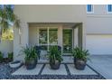 Inviting front porch with modern green door, blue chairs, and decorative potted plants at 2586 Prospect St, Sarasota, FL 34239