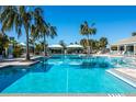 Community pool area with lounge chairs and cabanas under a sunny sky at 3632 Shimmering Oaks Dr, Parrish, FL 34219