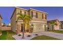 Two-story house with a light green exterior, two-car garage, and palm trees at 3809 Golden Oriole Pkwy, Sarasota, FL 34232