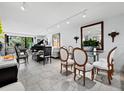 Bright living room with glass dining table and grand piano at 520 Bayport Way, Longboat Key, FL 34228