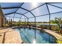 Screened-in pool with a spa and lake view at 6517 Willowshire Way, Bradenton, FL 34212