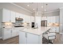 Modern kitchen with white cabinets, large island, and stainless steel appliances at 7845 Mainsail Ln, Sarasota, FL 34240