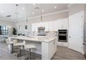 Modern kitchen with white cabinets, large island, and stainless steel appliances at 7845 Mainsail Ln, Sarasota, FL 34240