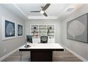 Home office with built-in shelves, desk, and large artwork at 7845 Mainsail Ln, Sarasota, FL 34240