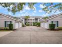 Inviting condo exterior with garages, lush landscaping, and a staircase to upper units at 905 Addington Ct # 203, Venice, FL 34293