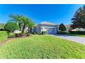 One-story home with gray exterior, palm trees, and a well-manicured lawn at 9750 53Rd E Dr, Bradenton, FL 34211