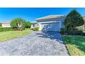 Single-story house with gray siding, two-car garage, and paved driveway at 9750 53Rd E Dr, Bradenton, FL 34211