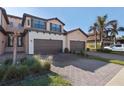Two-story townhome with brown garage and palm trees at 10817 Tarflower Dr # 202, Venice, FL 34293
