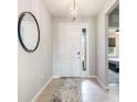 Bright entryway with tile flooring, a mirror, and a modern white door at 12689 Promenade Estates Blvd, Sarasota, FL 34238