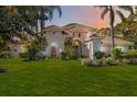 Two-story house with tile roof, fountain, and lush landscaping at sunset at 401 Walls Way, Osprey, FL 34229