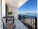 Outdoor balcony with chairs, table, and views of the water and skyline in the distance at 4822 Ocean Blvd # 10E, Sarasota, FL 34242