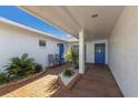 Brick walkway to a blue front door, flanked by potted plants at 6409 16Th Avenue Dr W, Bradenton, FL 34209